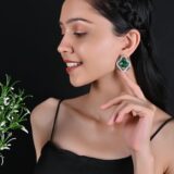 A woman wearing the Rhea earrings, highlighting their elegance and sophistication, perfectly complementing her stylish outfit